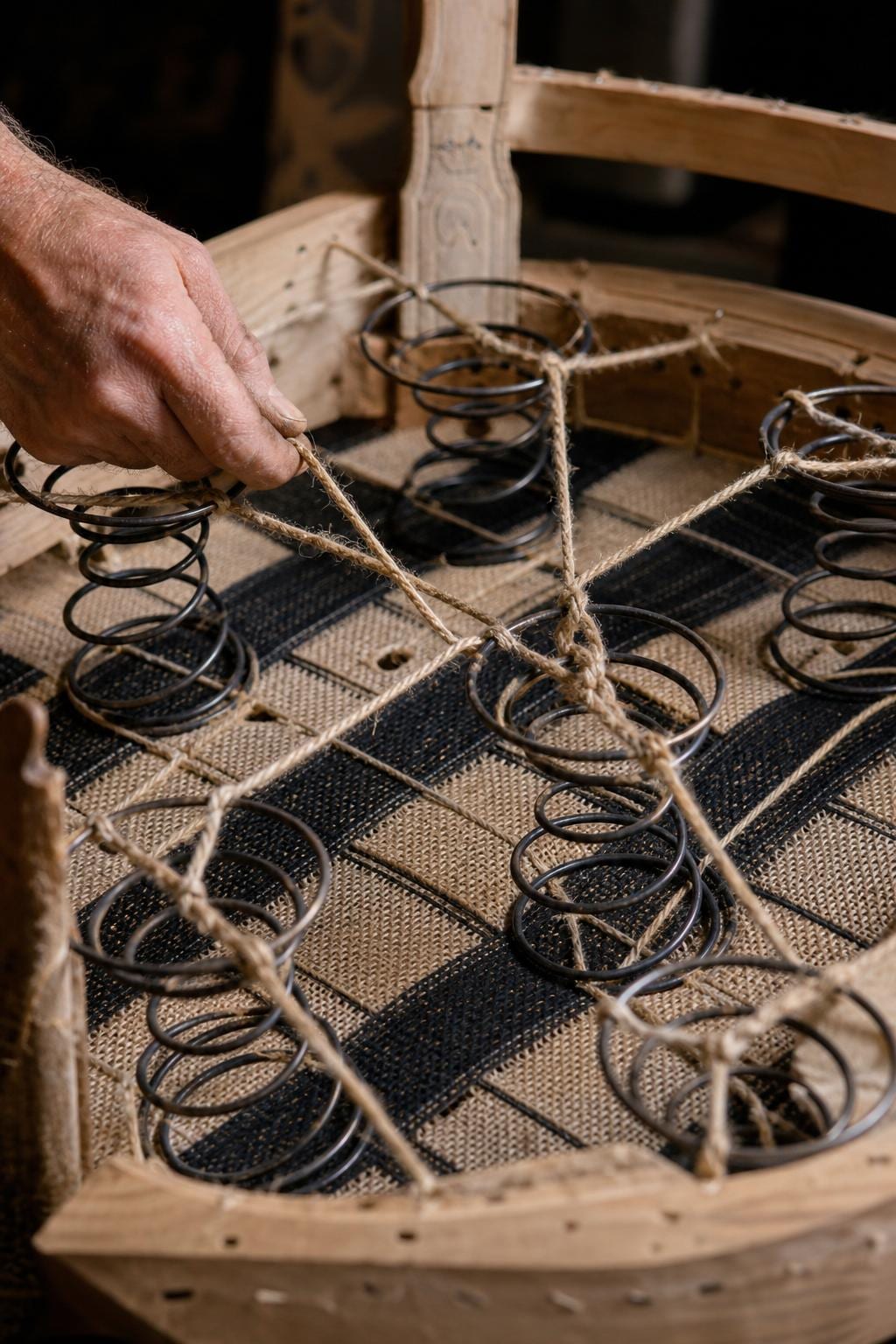 Hand-bound natural rawhide lashing wrapping a sculptural rattan frame — the McGuire signature