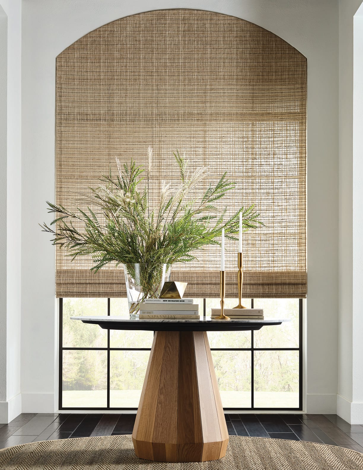 Hand-loomed natural-fibre shade installed at a tall window, filtering daylight into the room