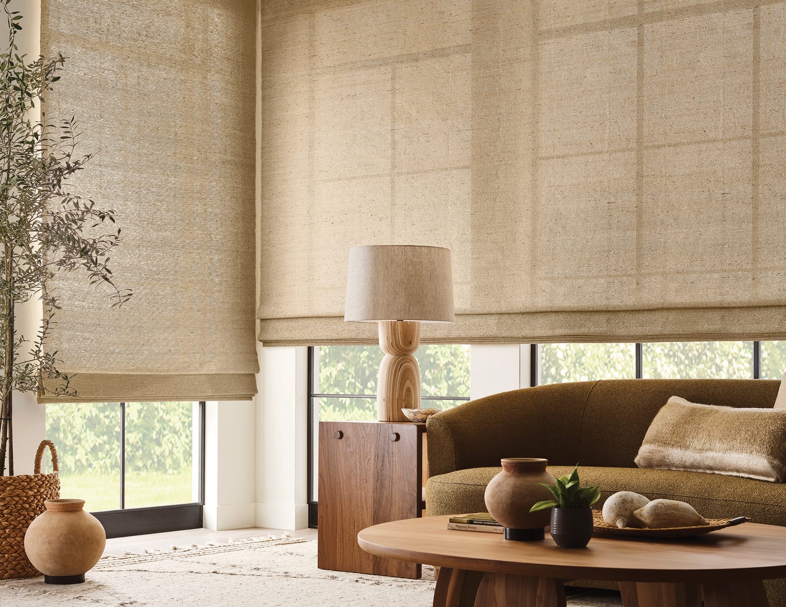 A woven roman shade at a tall window above a dining table, rope pendant overhead — filtered daylight across the room